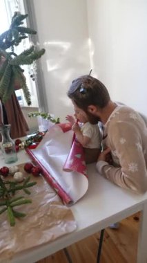 Bayram sezonunda hediyeleri paketlerken aile bağlarının ve birlikteliğin neşeli bir sahnesi.