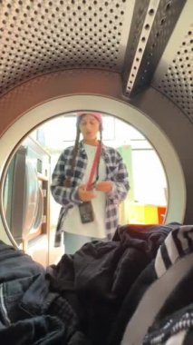 Neşeli bir an, genç bir insanın çamaşırhane dolu bir kurutucudan gizlice bakmasını ve keyif vermesini gösteriyor.