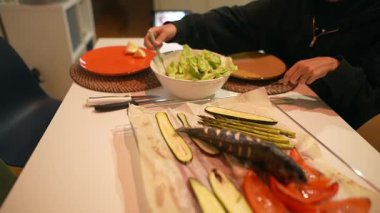 Izgara sebzeler, taze salata ve renkli tabaklar içeren canlı bir masa. Sağlıklı yemek için mükemmel..