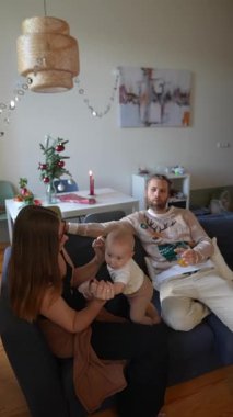 Sevgi dolu bir aile, sevimli bebekleriyle hoş ve rahat bir yuva ortamında vakit geçirmenin tadını çıkarıyor.