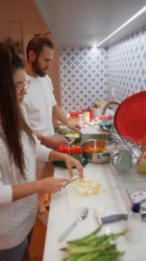 Bir çift, takım çalışmalarını ve mutfak becerilerini şık bir mutfakta sergileyerek, keyifli bir yemek pişiriyor.