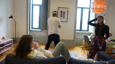 Bir grup arkadaş doğal ışıkla dolu şık ve parlak bir dairede keyif çatıyor.