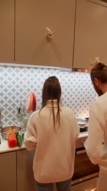 Sıcak bir mutfak ortamında, insan sıcak ve rahat bir ortam içinde neşeyle lezzetli yemekler hazırlıyor.