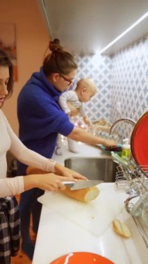 Sıcak ve keyifli bir aile anı. Mutfakta çekilen keyifli bir yemek pişirme ve bir bebek üzerinde bağ kurma anı.