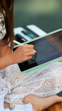 Bir insan piyano çalarken tablet üzerinde tasarım yaparken güzel bir şekilde yakalanan yaratıcı bir an.