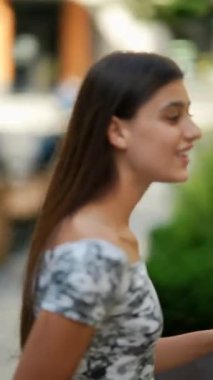 Genç bir kadın parlak bavuluyla canlı bir şehir ortamında yeni bir maceraya hazır bekliyor.