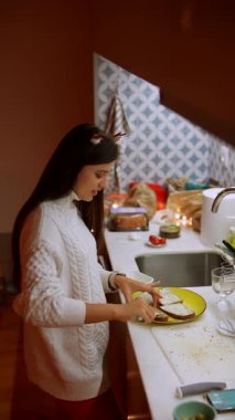 Sıcak, davetkar bir mutfakta, bir kadın ustalıkla lezzetli yemekler hazırlar, yaratıcılığını gösterir.