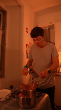 Genç bir adam, etkileyici mutfak becerilerini ve tekniklerini sergileyerek sıcacık bir mutfakta et hazırlıyor.