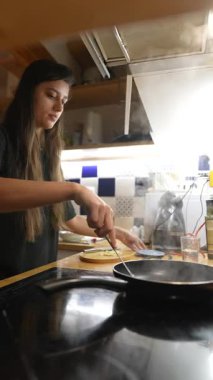 Genç bir kadın, modern mutfağında çeşitli lezzetli yemekler pişiriyor. Mutfak becerilerini sergiliyor.