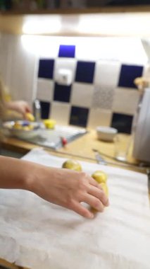 Modern bir mutfakta stil dolu bir insan, kağıt üzerine yerleştirilmiş taze patatesleri ustalıkla idare eder.