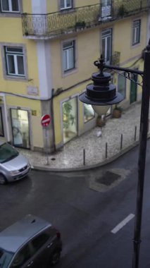 Yağmurlu bir şehir akşam sahnesi, arabaların sürdüğü ve bir yayanın modern mağazaların ve binaların yakınında yürüdüğü