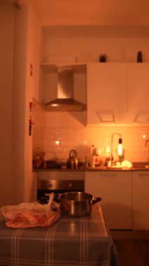 Yemek tencereleri, hafif ışıklandırma ve özenle hazırlanmış malzemelerle enfes, sıcak bir mutfak atmosferi oluşturulur.