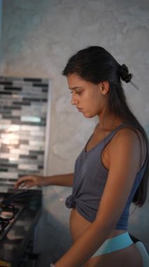 Yetenekli genç bir kadın şık ve modern bir mutfak ortamında lezzetli bir omlet hazırlıyor.