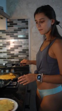 Yetenekli bir kadın şık mutfağında nefis bir kahvaltı hazırlar. Mutfak yeteneklerini sergiler.