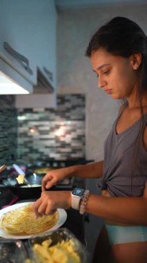 Kararlı genç bir kadın, zarif modern mutfağında yeteneklerini sergileyerek lezzetli bir yemek hazırlıyor.