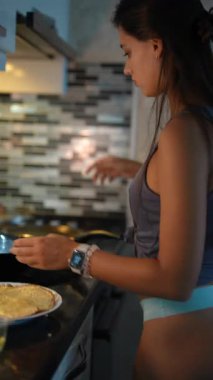 Zarif, modern bir mutfakta ustalıkla ve özgüvenle lezzetli yemekler hazırlayan bir kadın aşçılık yeteneklerini sergiliyor.