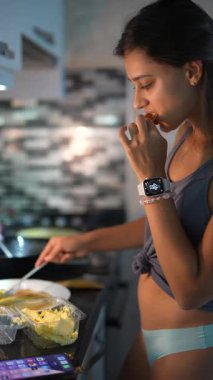 Yetenekli bir kadın modern mutfağında ustalıkla yemek hazırlıyor, canlı mutfak yaratıcılığını sergiliyor