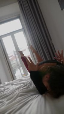 Yetenekli bir dansçı olağanüstü esneklik ve dinamik hareketi güzel aydınlatılmış bir yatak odasında sergiliyor.