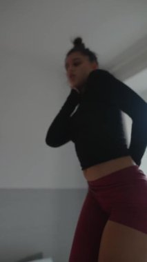 Genç bir dansçı enerjik bir şekilde rahat bir yatakta canlı hareketler sergiliyor, canlı enerji yayıyor ve eşsiz bir stil sergiliyor.