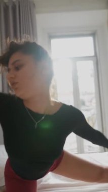 Güneşli ve güzel bir odada, bir kadın güne neşe katmak için sakin bir sabah esnemesi yapar.