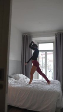 Dinamik bir dansçı, rahat bir arka planda hareketlerini ve hareketli pozlarını sergiliyor.