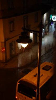 Yağmurlu bir gece sokak manzarası, güzel aydınlatılmış bir sokak direği, şehir ayarları cazibesini sergiliyor