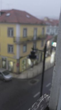 Sis içindeki büyüleyici sarı binalı sakin bir caddenin puslu görüntüsü eşsiz bir atmosfer yaratıyor.