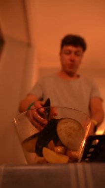 Becerikli bir birey ağız sulandırıcı ve lezzetli bir yemek için taze malzemeler hazırlar sıcak, davetkar bir ışıkta.