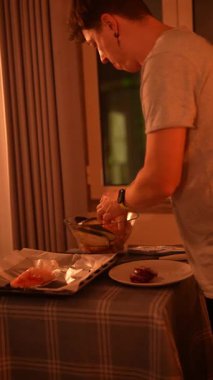 Bir insan gece lezzetli bir yemek hazırlıyor, rahat ve rahatlatıcı bir atmosferde aşçılık becerileri sergiliyor.