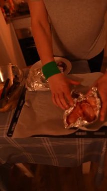 Parlak folyoyla lezzetli yemekler hazırlayan, rahat bir mutfakta yemek yapma tekniğini sergileyen biri.