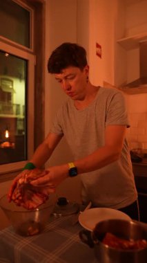 Parlak bir mutfakta, genç bir adam hevesle taze malzemeler hazırlar, rahat bir atmosfer yaratır.