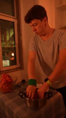 Sıcak ve davetkar bir mutfak ortamında insan sıcak bir akşam yemeği hazırlar.