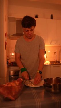 Bir insan sıcak bir mutfakta lezzetli yemekler hazırlıyor. Işıklandırma ve çeşitli aşçılık görevlerine odaklanıyor.