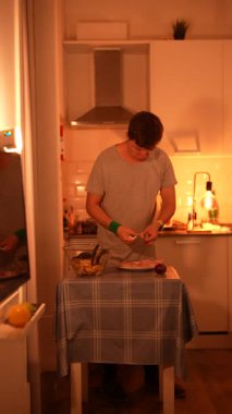 Sıcacık bir mutfakta ustalıkla lezzetli yemekler hazırlayan bir insan, rahat bir yemek atmosferi sergiliyor.