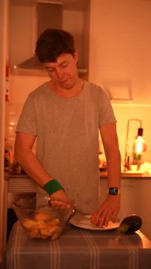 Bir birey sıcak ve davetkar bir mutfak ortamında taze malzemeleri özenle dilimliyor.