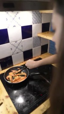 Tavada cızırdayan karides, canlı renkler sergiliyor ve yemek pişirme konusunda uzman.