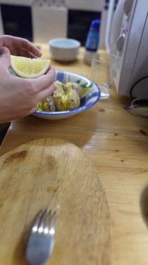 Elleri ustalıkla canlı limon dilimleri ve taze meyve suyu hazırlar. Mutfak ortamında çeşitli kullanım alanları için.