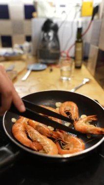 Çok yetenekli bir şef modern bir mutfak ortamında taze malzemeler kullanarak lezzetli karidesleri ustalıkla hazırlar.