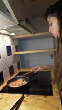 Odaklanmış bir şef, karidesi özel bir mutfak ortamında ustalıkla sarıyor.