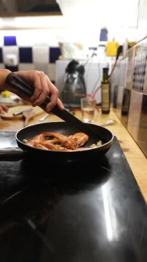 Yetenekli bir aşçı güzel bir mutfak ortamında fırında lezzetli karidesleri ustalıkla hazırlar.