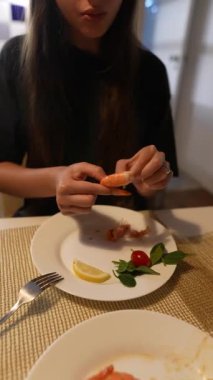 Bir insan, limonlu ve otlu lezzetli bir karides yemeğinden zevk alır ve mükemmel bir yemek oluşturur.