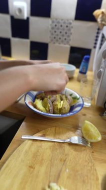 Bir el ustalıkla lezzetli bir yemek hazırlar. Taze patates, lezzetli limon ve hoş bir mutfakta aromatik baharat ile.