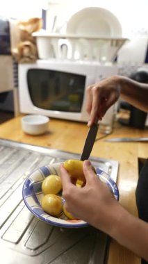 Modern bir mutfakta rengarenk sebzeleri ustalıkla soyan bir kadın mutfak uzmanlığını sergiliyor.