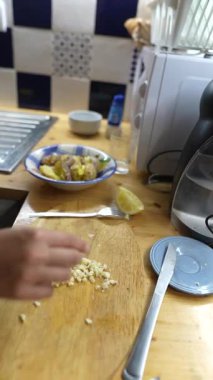 Kırsal bir ahşap masada sergilenen limon hazırlığında sarımsaklı patateslerin yer aldığı enfes bir mutfak sahnesi.