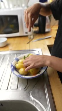 Bir insan lezzetli ve lezzetli bir yemek için mutfakta taze, organik patatesleri ustalıkla kesip hazırlıyor.