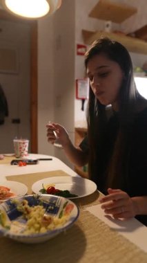 Sıcak bir yemek ortamında keyifli ve sağlıklı bir yemeğin tadını çıkaran odaklanmış bir birey.