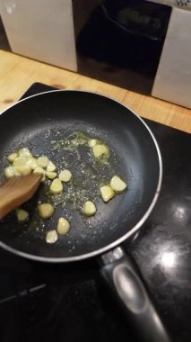 Yemek pişirme süreci, çeşitli lezzetli tarifleri geliştirmek için mükemmel olan sıcak yağda sarımsak cızırtısını vurgular.