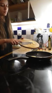 Sıcak bir mutfakta, bir insan taze malzemeleri dilimleyip kızartarak lezzetli yemekleri ustaca hazırlar.