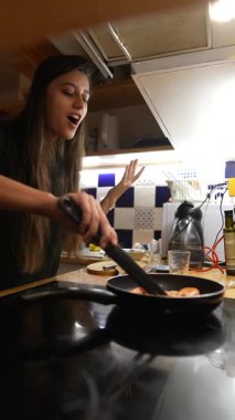 Modern bir mutfakta, genç bir aşçı ustalıkla bir gurme yemeği hazırlar, canlı malzemelerle yeteneklerini sergiler.