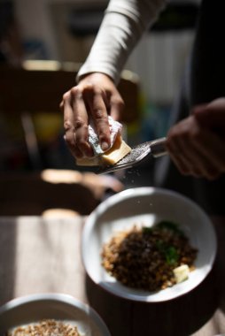 Bir el rengarenk bir tabağa tereyağı sürer. Sıcak, davetkar bir ortamda mutfak yaratıcılığı sergiler.